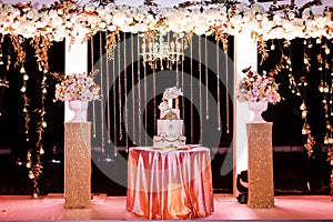 Table with a wedding cake, candles, light and flowers. wedding decoration