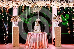 Table with a wedding cake, candles, light and flowers. wedding decoration