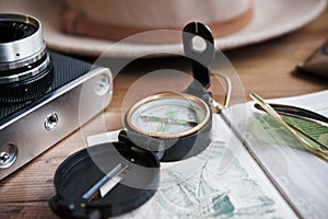 Table whith passport, vintage camera, compass, sunglasses and hat.