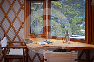 Table between the window of the luxury yurt in the forest photo