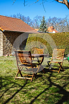 Table with wooden chairs in the garden in the courtyard
