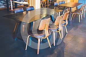 Table and wooden chairs in a modern coffee shop.