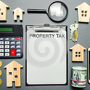 Table with wooden houses, calculator, coins, magnifying glass with the word Property Tax. Property taxes. Calculation of interest