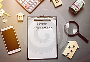 Table with wooden houses. Real estate. Lease agreement is a contract between a lessor and a lessee that allow lessee rights to use