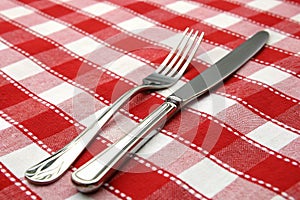 Tableknife and fork on red checked tablecloth