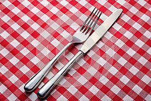 Tableknife and fork on red checked tablecloth