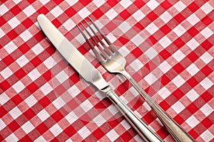 Tableknife and fork on red checked tablecloth