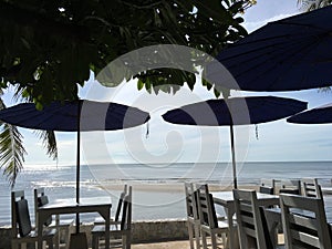 Tables and beach umbrellas by the sea at sundawn at Huahin , Thailand