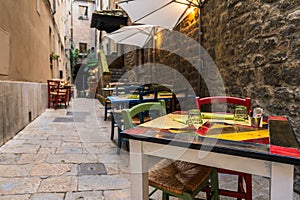 Tables and chairs in a narrow alley