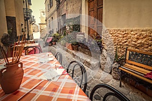 Tables and chairs in a narrow alley in old town Castelsardo