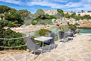 Tables with chairs overlooking Cala Ferrera beach