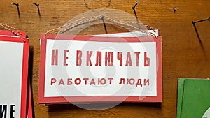 Tables at a factory or production with Russian text from the times of the USSR. Hazard warning text. Do not include people in the