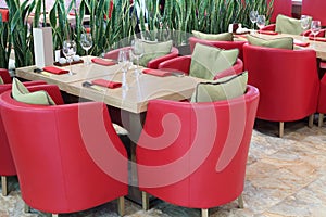 Tables with glasses, soft red armchairs