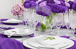 Tables set for an event party or wedding reception. luxury elegant table setting dinner in a restaurant. Beautiful purple flowers