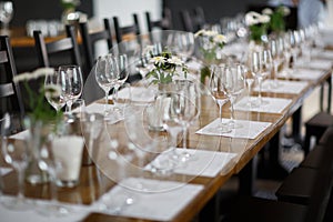 Tables setting at a luxury wedding. Table for guests. Dishes and drinks. Floral decorating, white chairs and table