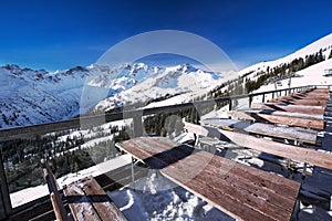 Tables on terrace covered by fresh snow near ski slopes on the t