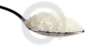 Tablespoon of coarse sea salt against white