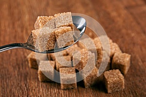 Tablespoon with cubes of brown sugar