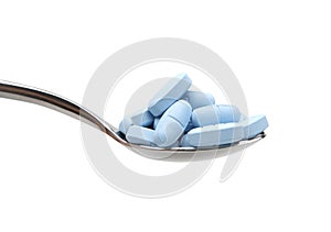 Tablespoon filled with blue pills