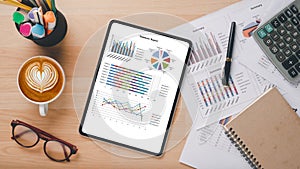 Tablet with charts and reports, pen, calculator, notebook, mouse and keyboard on office desk workplace