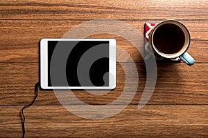 Tablet and coffee on wood with wire