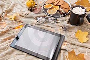 Tablet computer, hot chocolate and autumn leaves