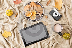 Tablet computer, hot chocolate and autumn leaves