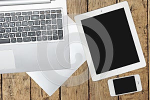 Tablet, computer, smartphone and paper on wood table