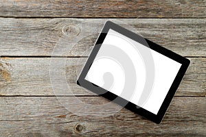 Tablet computer with white screen on grey wooden background