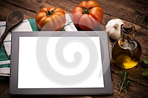 Tablet with cooking utensil and ingredients View from above