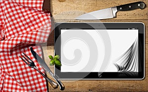 Tablet and Cutlery on a Table with Tablecloth