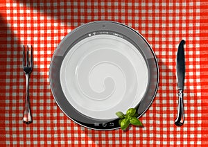 Tablet and Cutlery on a Table with Tablecloth