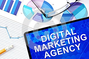 Tablet with digital marketing agency, graphs and glasses. photo