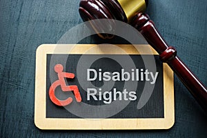 Tablet disability rights and gavel on a dark surface.