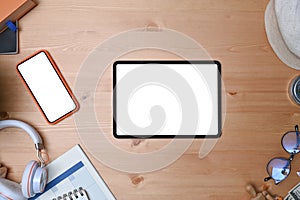 Tablet, eye glasses, headphone, coffee cup, smart phone and notebook on wooden background.