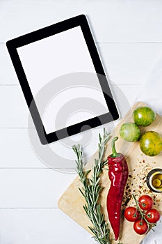 Tablet with fresh cherry tomatoes, rosemary and pepper on cutting board on a white background of the old wooden boards vintage top