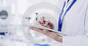 Tablet in the hands of a scientist, medical research professional or healthcare professional in a science lab. Closeup