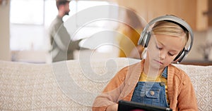 Tablet, headphones and parents fighting with a girl sitting on a sofa in the living room of her home during an argument