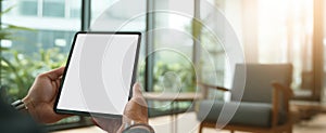 The Tablet Held in Hands Against a Modern Office Background.AI generated image