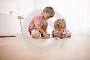 Tablet, kids and siblings on a floor with cartoon, gaming or streaming movie at home. Digital, learning and boy children