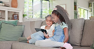 Tablet, kids and sisters playing games online while sitting on a sofa in the living room of their home together