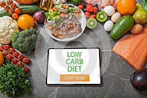 Tablet on a kitchen table surrounded by healthy products, concept of diet apps