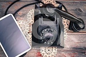 Tablet lying alongside a retro rotary telephone