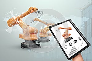 A tablet in a man`s hand controlling robotic arms in a modern factory. Iot technology concept, smart factory. Digital