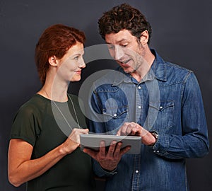 Tablet, man and woman in studio together with casual style, connection and networking for creative professional