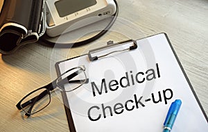 A tablet with a medical inscription. Medical desk with blood pressure monitor