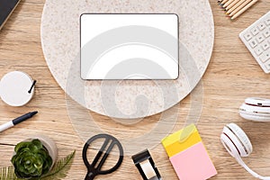 Tablet mock up on office desk table top view with stationery,notebook,plant on wooden table background.smart phone screen for