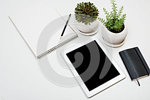 Tablet mock-up and office supplies on white tabletop background