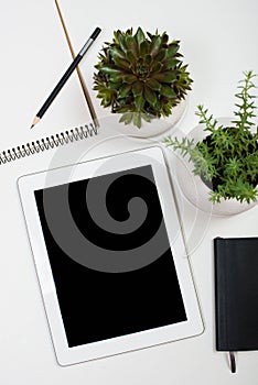 Tablet mock-up and office supplies on white tabletop background