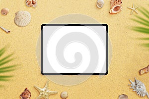 Tablet mockup on beach sand surrounded by sea shells and palm leaves